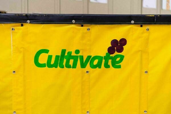 Close up view of a bright yellow large bin, with the word "Cultivate" in green and a drawing of grapes in purple.